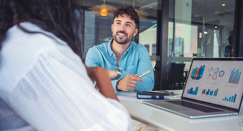 Person working with a client discussing consulting pricing models on a laptop